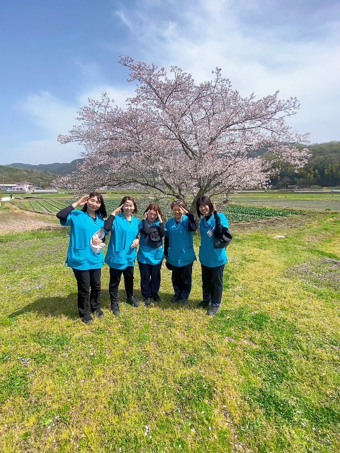 桜の木の前に並ぶハッピーズのスタッフ